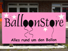 Ein rosafarbenes Schild mit weißen Sternen, schwarzen Ballons und der schwarzen Aufschrift BalloonStore Alles rund um den Ballon.