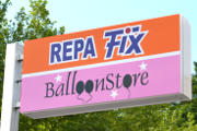 Bunte Leuchtreklame mit der Aufschrift REPA Fix oben und der Aufschrift BalloonStore unten.